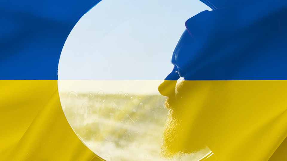 Seafarer looking out a porthole with a Ukraine flag superimposed over the top.
