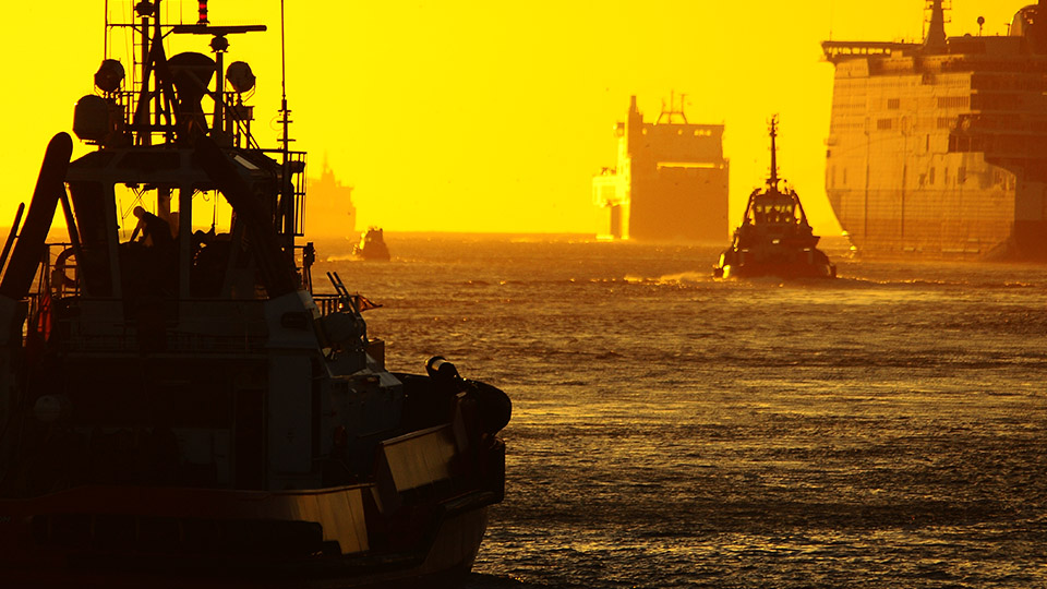 Ships approaching a port during a sunset 